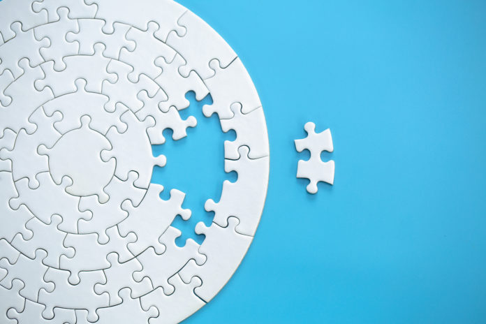 White jigsaw puzzle pieces on a blue background. Problem solving