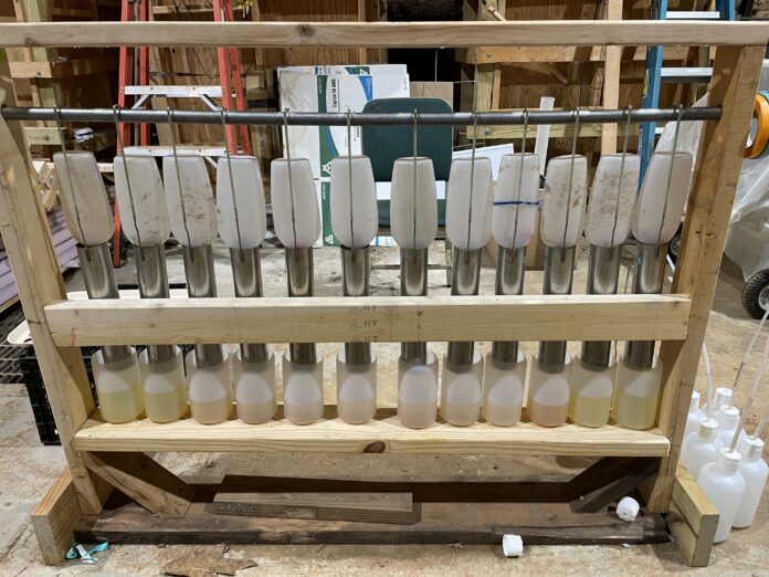 Figure 1. Setup to test the tracer dye and PFAS removal percentages as liquid leaches through a soil and sawdust blend. Each cylinder contains a different mix of soil and sawdust.