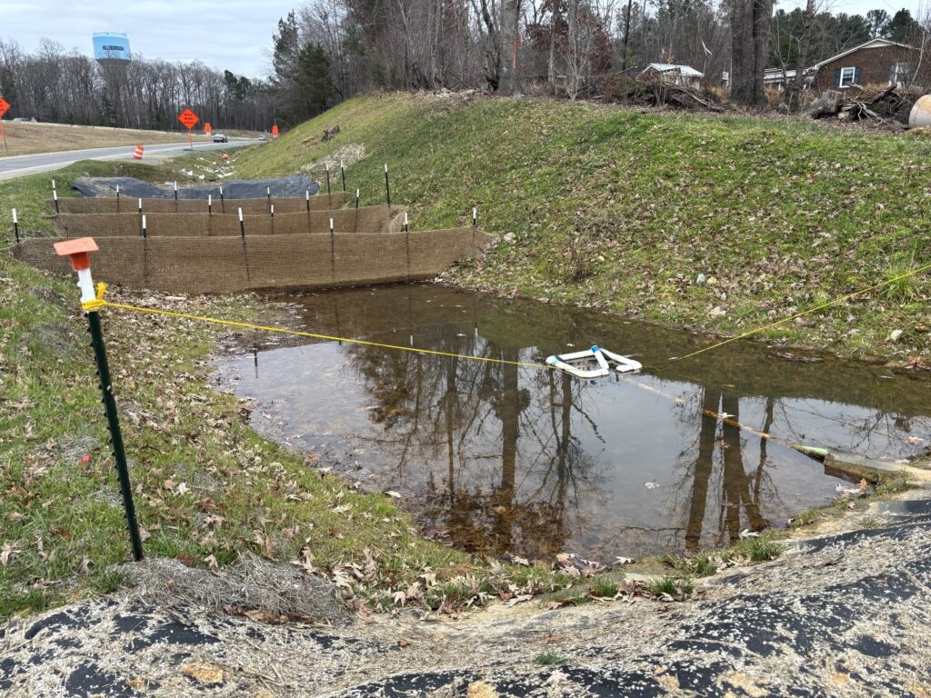 A skimmer resting in a standing pool near the outlet of the basin.