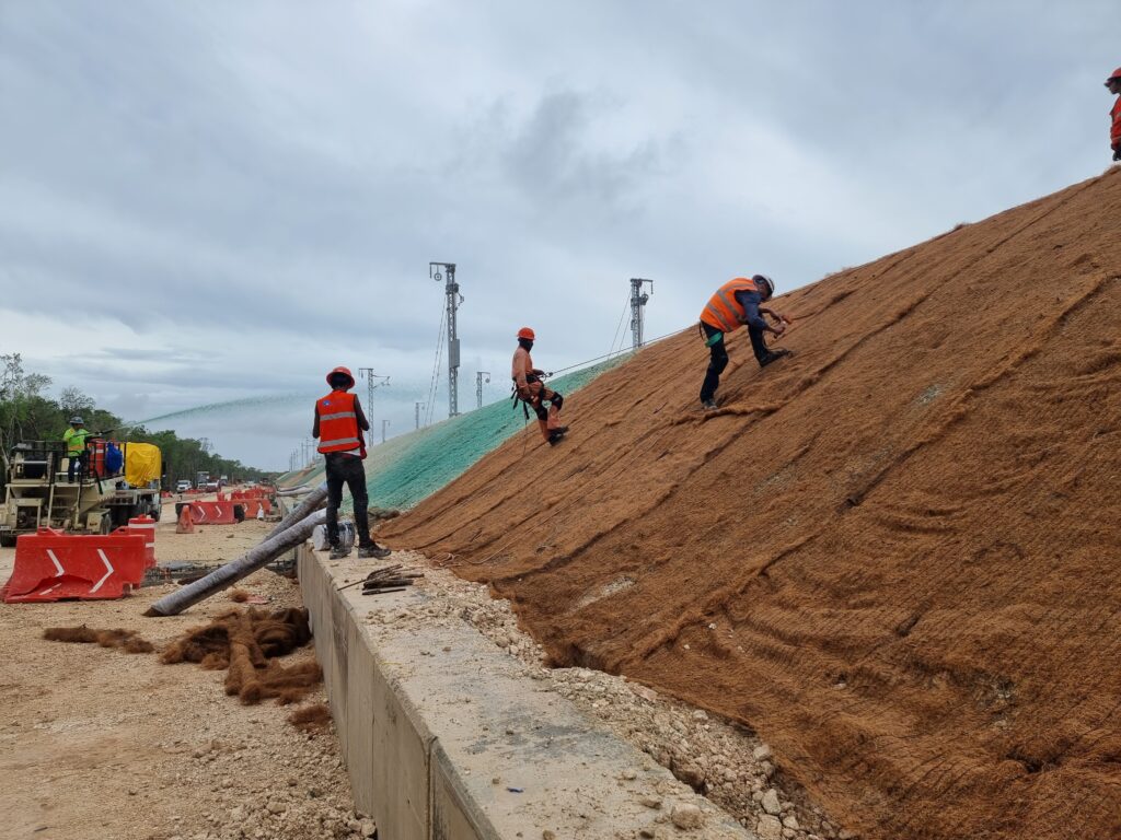 Figure 9. Coconut fiber blanket being installed after hydroseeding was applied.
